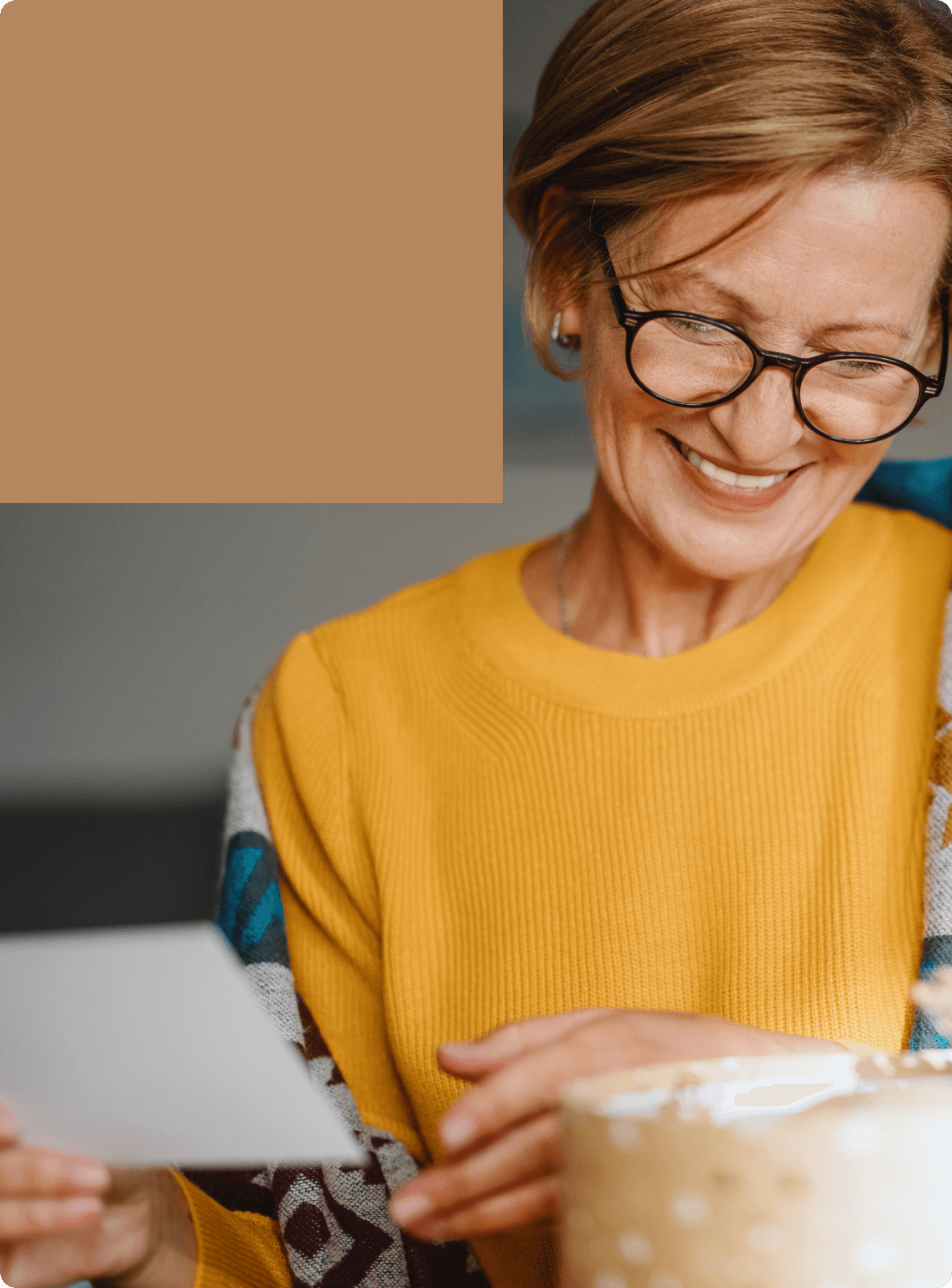A mature woman wearing glasses prepares lettermail.
